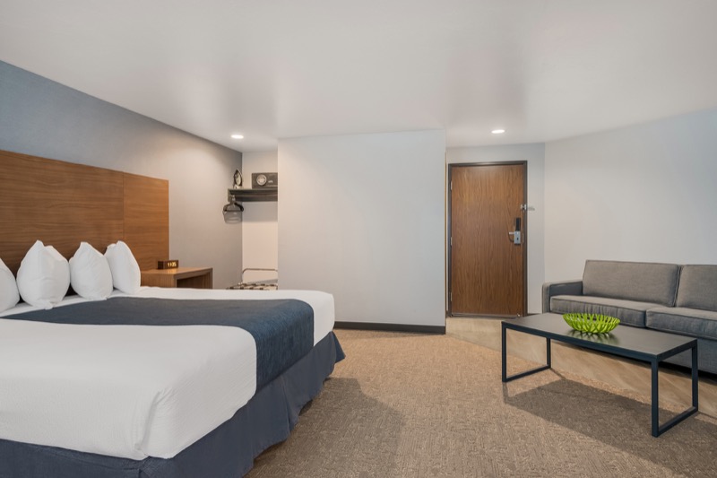King Suite showing king bed, open living area with sofa and coffee table, and suite entrance door