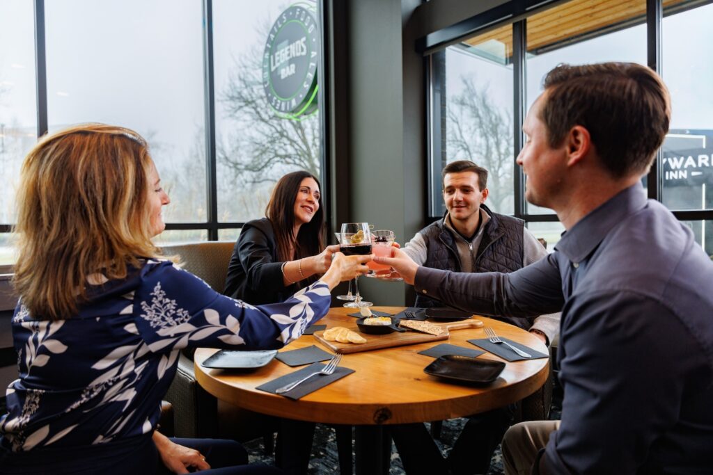 Coworkers toasting at Holiday Party in Legends Bar at Hayward Inn in Eugene, OR